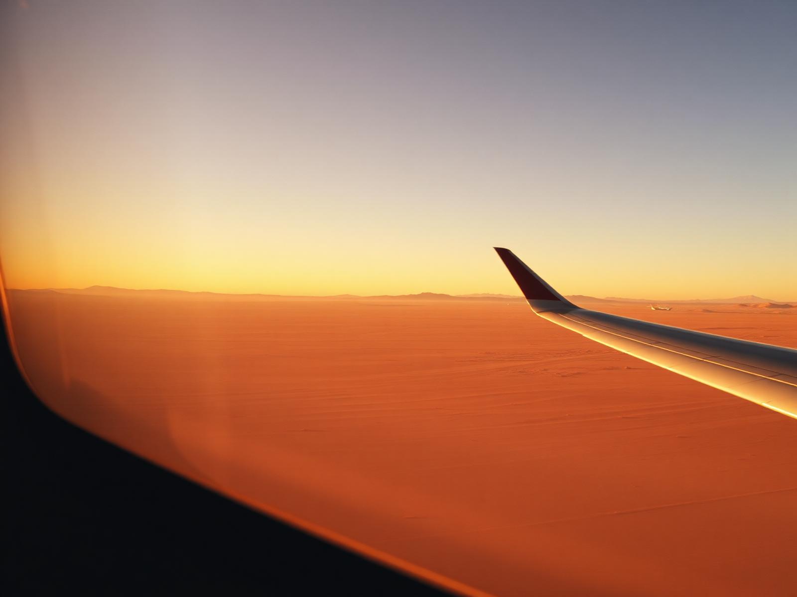 Desert horizon seen from an aircraft window at golden hour